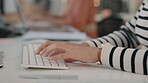 Hands, typing and arthritis with a business woman holding her wrist in pain while working on a computer in the office. Fingers, keyboard and cramp with a female employee sitting at a desk at work