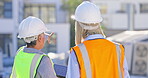 Back, teamwork and discussion with construction worker women outdoor in a city together for a building project. Architecture, engineering and planning with a designer talking to a partner for safety