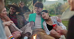 Festival, bonfire and group of young people at a party or outdoor gathering together at a fire as friends to celebrate. Bonding, camping and freedom for youth on a vacation or holiday adventure 