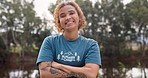 Smile, portrait of woman with arms crossed at summer camp and happy counsellor in nature with pride. Forest, lake and face of camping volunteer girl with confidence, support and leadership training.