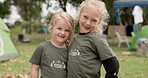 Family, children and face of girls in a park for camping, fun and bonding on vacation outdoors. Love, kids and portrait of sisters hug, smile and happy in nature, playful and enjoy holiday in woods