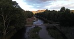 Drone, river and landscape of nature in the countryside, woods and the road or a bridge. Morning, calm and an above view of a lake, forest and street or highway for travel by a forest for peace