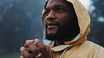 Coffee, morning and a black man hiking in nature with a blurred background of cold, winter weather. Thinking, raincoat and face with a young male hiker in the woods or forest to explore for adventure