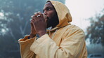 Coffee, morning and black man hiking in the forest with a blurred background of cold, winter weather. Thinking, raincoat and face of a young male hiker in the woods or nature to explore for adventure