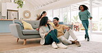 Happy family, parents and children running in a living room with energy, happiness and love. Multiracial man, woman and girl kids together at home for fun, play and quality time with a hug and care