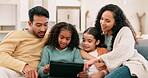 Family, parents and children with a tablet in living room for education, learning or games. Multiracial man, woman and girl kids together at home with tech and internet for streaming and development