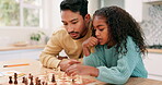 Family, father and child playing chess at home while teaching or learning board game. Multiracial man and kid partner together to play for fun, checkmate or competition for development and bonding
