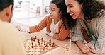 Family, mother and child playing chess at home while teaching or learning board game. Latino woman and girl kid partner together to play for fun, checkmate or competition for quality time and bonding
