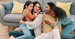 Happy family, parents and children hug at home with care, happiness and love. Multiracial man, woman and girl kids together for fun, play and quality time on a living room floor to relax with a smile