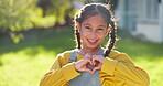 Face, child and heart hands of girl outdoor in garden, backyard of home and sign for fun, peace and care. Portrait, happy female kid and hand gesture of love, support and emoji in summer in Colombia