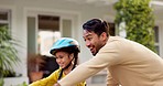 Dad, kid and teaching on bike outdoor in driveway of neighborhood for family support, help and trust. Excited father, happy young girl and learning on bicycle for fun, skill or childhood development