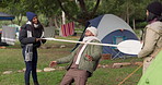 Camping, limbo and friends playing a game with bar and being competitive on an outdoor holiday, adventure or vacation. Happy, event and group of people at a party in a forest doing dancing challenge