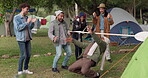 Camping, limbo and people playing a game with bar and being competitive on an outdoor holiday, adventure or vacation. Happy, event and group of friends at a party in a forest doing dancing challenge