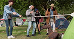 Party, limbo and friends playing a game with bar and being competitive on an outdoor holiday, adventure or vacation. Happy, event and group of people camping in a forest doing dancing challenge