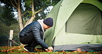 Man, build and tent at camp in forest for adventure on holiday for relaxing in environment. Backpack, guy and shelter for travel n in nature with person or equipment in environment for vacation.
