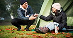 Coffee, camping and a couple at a tent outdoor in nature with love, care and adventure. A young man and woman happy while at a camp site in winter for holiday, travel or vacation to relax in a forest