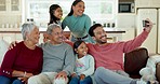 Family, selfie and grandparents with children on sofa for bonding, quality time and memories in living room. Home, kids and mom, dad and senior parents on couch for picture, post and social media