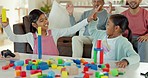 Girl kids, table and building blocks with high five, learning and development in lounge at family home. Children, plastic toys and celebration with education, achievement and relax in living room