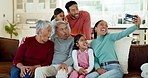 Family, silly selfie and grandparents with kids on sofa for bonding, quality time and memories in living room. Home, children and mom, dad and senior parents smile for picture, post and social media