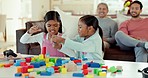 Girl kids, table and building blocks with play fight, learning and development in lounge at family home. Children, plastic toys and playful conflict with dad, grandfather and relax in living room