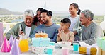 Phone, video call and big family at a party celebration with a dessert cake and presents or gifts. Happy, smile and people on a virtual conversation to celebrate with young man at a birthday event.