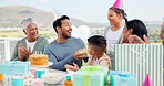 Happy, celebrate and big family at an outdoor birthday party with a dessert cake and presents. Happiness, smile and people clapping hands in celebration for a young man at event outside their home.