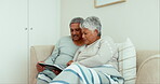 Talking senior couple, relax and tablet on sofa with home living room blanket for love, movies and streaming internet show. Happy woman, elderly and man on technology for media choice on website app