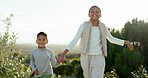 Children, boy and girl in park, holding hands and walking together with smile on face in summer sunshine. Siblings, kids and love for bonding, play and happy in field, backyard and running on holiday