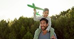 Father, son and shoulders with plane, toys and games in nature, park or backyard in summer sunshine. Man, boy and piggyback with airplane, playing and bonding with love, care and freedom on holiday