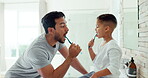 Dad, boy child and brushing teeth in bathroom for dental wellness, morning routine or teaching healthy habits. Family of father, kid and cleaning mouth with toothbrush for self care of fresh breath