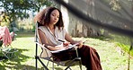 Camping, morning and a woman writing in a book for travel notebook, journal or summer memory. Relax, reading and a girl or person in a chair while on a camp or document for holiday goals in nature