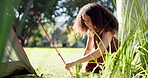 Tent, outdoor and a woman with a camping setup in a forest for holiday or adventure. Vacation, nature and a young girl with a hammer for shelter in the woods for a break, trekking or gear on a camp