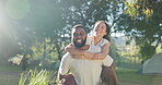 Love, piggyback or interracial couple walking in nature outdoors together while bonding for adventure. Summer, travel or romance with a happy man smiling with woman in the woods or forest to explore