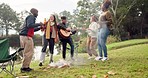 Friends, campfire and guitar with singing, dancing and happy together in nature, woods or park for vacation. Men, women and excited with beer, chat or camping by bonfire for music, forest and holiday