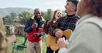 Singing, camping or happy friends with guitar dancing together in nature, woods or park on vacation. Men, women or fun people with beer or drinks by bonfire or campfire for music in forest on holiday