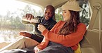 Road trip, coffee and happy couple relax in car, nature and winter adventure together with love, freedom and smile. Camp journey, black man and woman with hot drink in van, holiday at lake in camper.