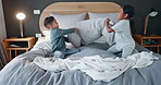 Night, happy and children pillow fight on a bed for fun, playing and bonding together. House, funny and kids, family or friends with a game in the bedroom for crazy, laughing and siblings together