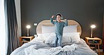 Young kid, dancing and bed jump at home with music and happy from song in morning. Youth, dancer and headphones with dancer and comedy in a house bedroom with a child and energy with radio audio