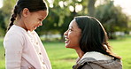 Child, mother and hug at a park outdoor in nature for happiness, adventure or fun play. Woman kiss a girl kid on hands in forest for family travel, wellness and support for freedom with love and care