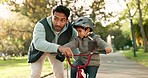 Teaching, bicycle and father with his son, support and talking with happiness, learning and safety. Male parent, kid and toddler outdoor, cycling and teaching with child development, bike and helping