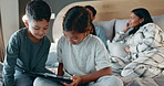 Tablet, brother and sister on the bed of their parents on a blurred background at night together to relax. Kids, siblings hugging or bonding in the bedroom with mom and dad sitting behind as a family