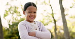 Child, smile and happy portrait at a park outdoor in nature for happiness, adventure or fun play. Face of latino kid with arms crossed and confidence in forest for travel, wellness and freedom