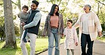 Nature, bonding and family on a walk in a park for fresh air, exercise and conversation together. Happy, smile and kids with their parents and grandmother talking in a green garden for spending time.