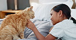 Children, bed and a girl petting her cat in the morning for bonding in a home with love, trust or care. Kids, bedroom and pet with an adorable female child stroking a kitten as friends in a house 