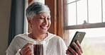 Happiness, home and senior woman with cellphone is reading with coffee in house. Technology, smile and elder female is streaming for news or information with internet on online app with tea in house.