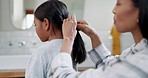 Mother, little girl and tying hair for morning grooming, routine or getting ready to start day at home. Mom helping daughter tie hairstyle in bathroom with hug for gratitude, love and care in house