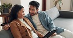 Talking, happy and interracial couple with a tablet on the sofa for a website, search or social media. Relax, laughing and a man and woman speaking while reading from technology together in a house