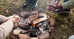 Campfire, hands or people outdoor in nature for fun, adventure and travel in woods. Camping, friends group and reaching over wood fire or flame at camp site for holiday, warm and freedom closeup