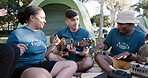 Guitar, dance and camping with a volunteer group sitting in a circle together for bonding. Music, smile and freedom with young community friends having fun on their campsite in nature for charity