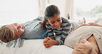 Happy family, bed and kid playing in a bedroom with mother and father as bonding with happiness together as a family. Crazy, funny and child with love or care for mom and dad in the morning at home